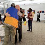Two people hugging in an art gallery