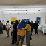 A crowd of people in an art gallery