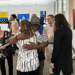 Two people hugging with a crowd of people behind them