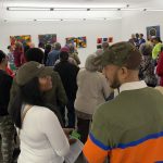 Crowd of people standing in an art gallery