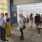 People standing around in an art gallery talking to each other