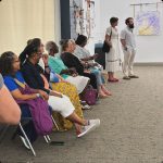 People sitting in chairs lined up against the wall
