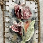 Art depicting a flower and petals on a canvas with twine with sticks as the border