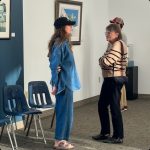Two ladies standing face to face and talking to each other
