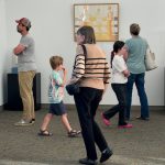 Group of people in an art gallery walking around.