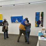 Two people hugging in an art gallery