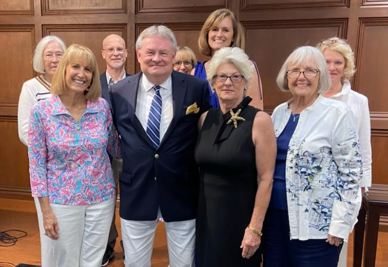 Group photo of gentleman in sport court surrounded by several ladies