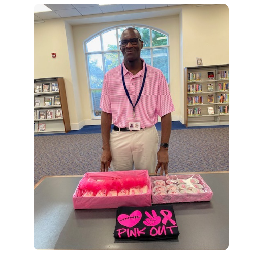 Michael standing in front of pink cupcakes