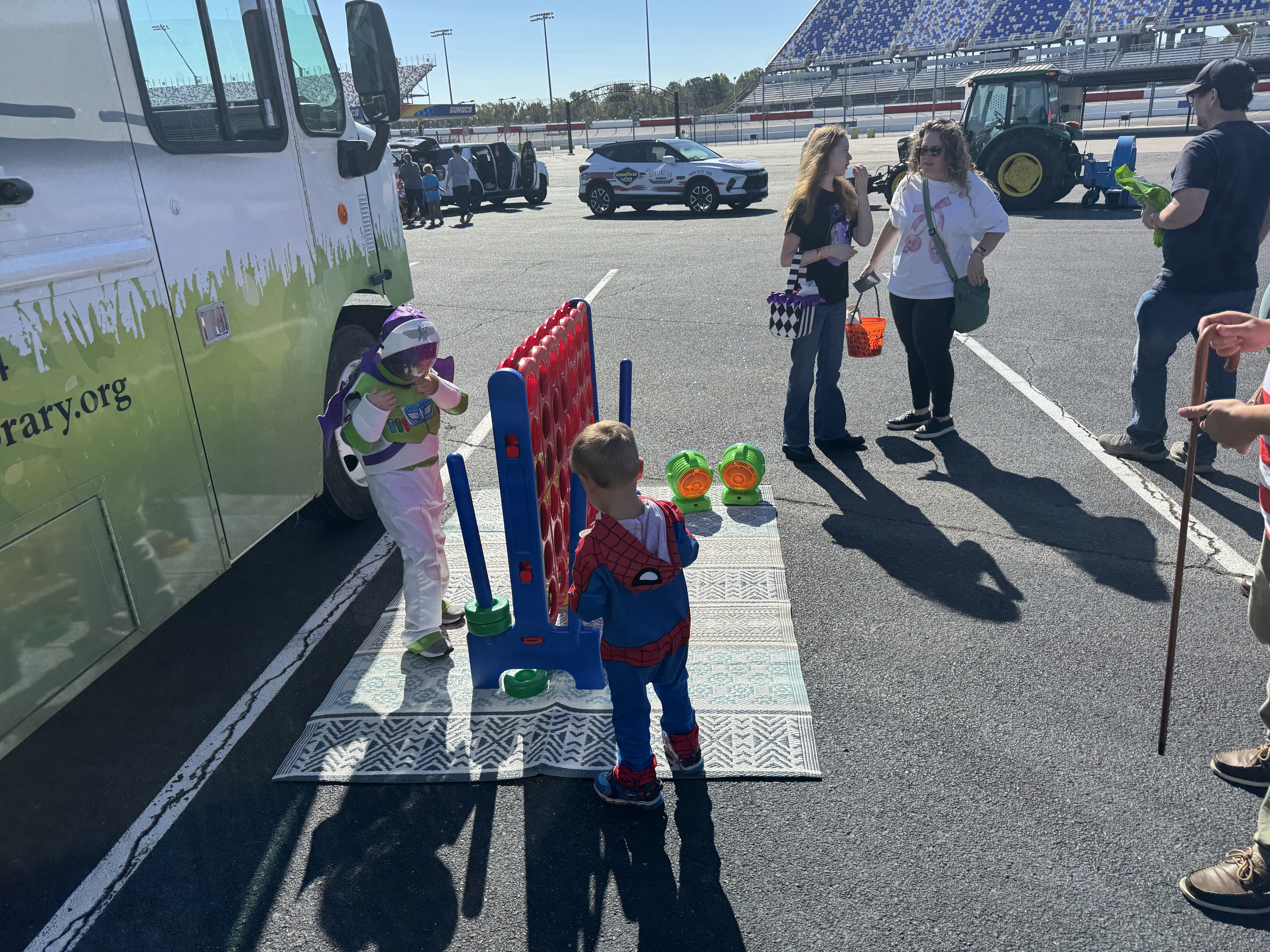 Children playing connect four in front of bookmobile