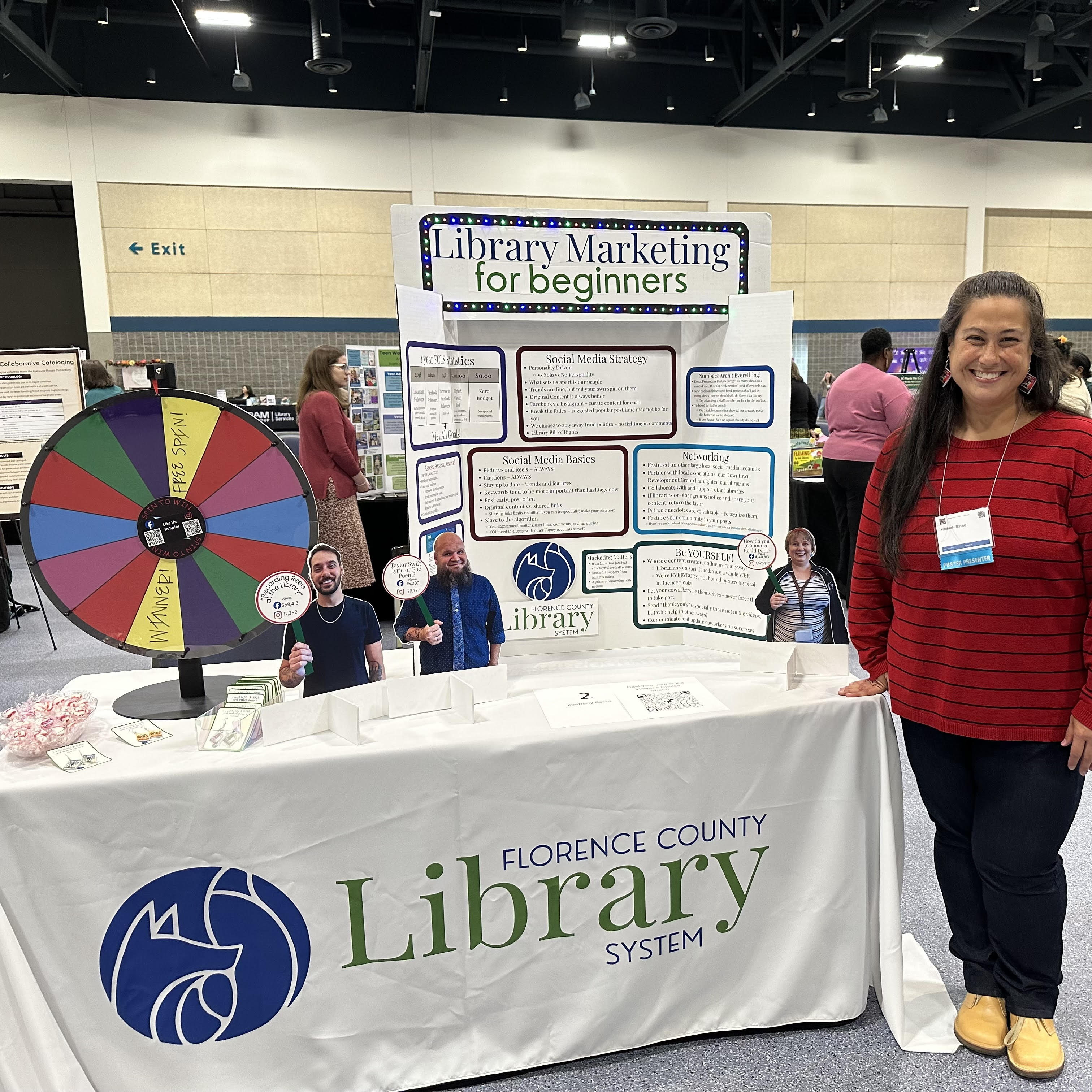 female standing next to trifold display