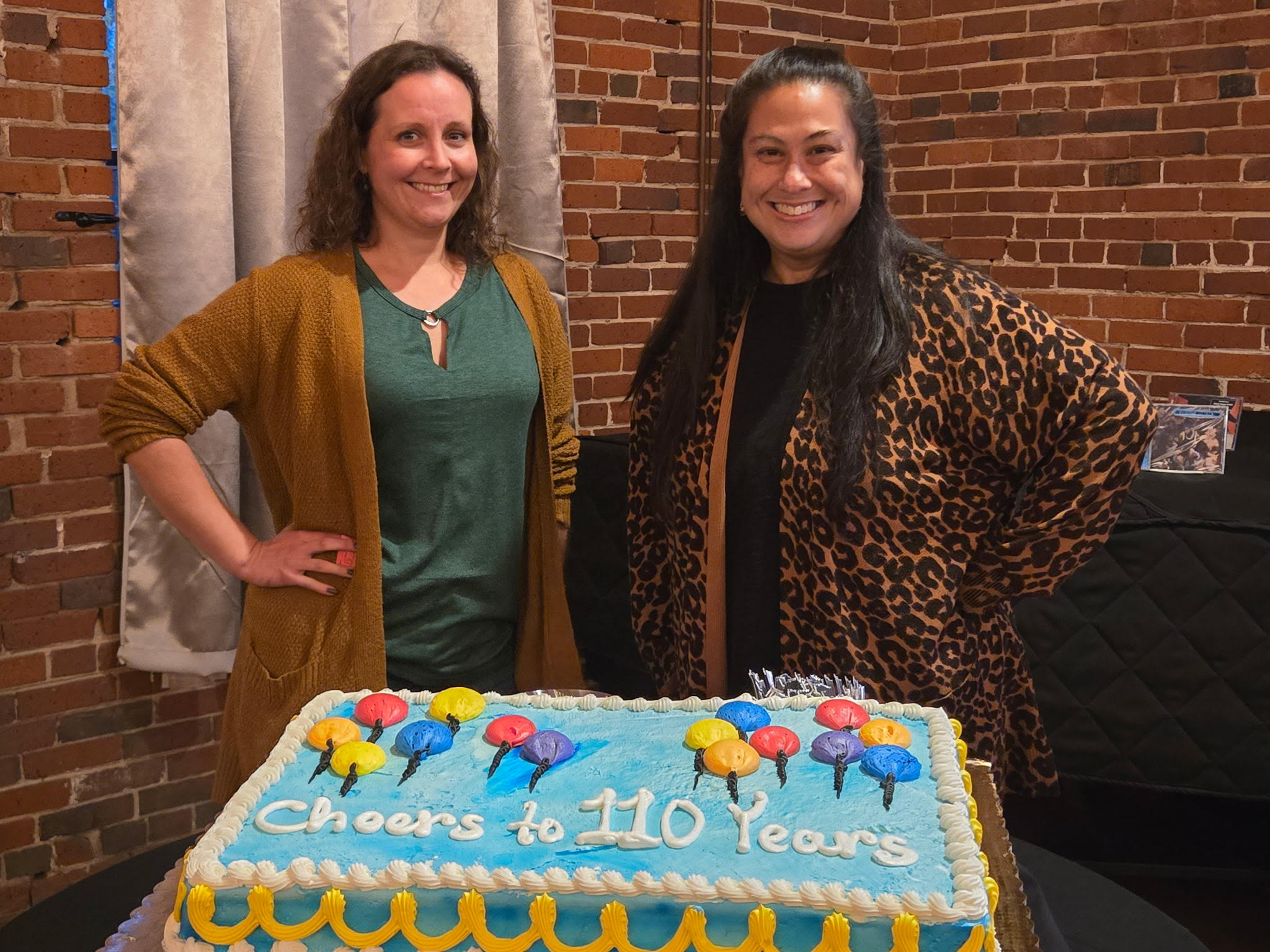 two women in front of cake