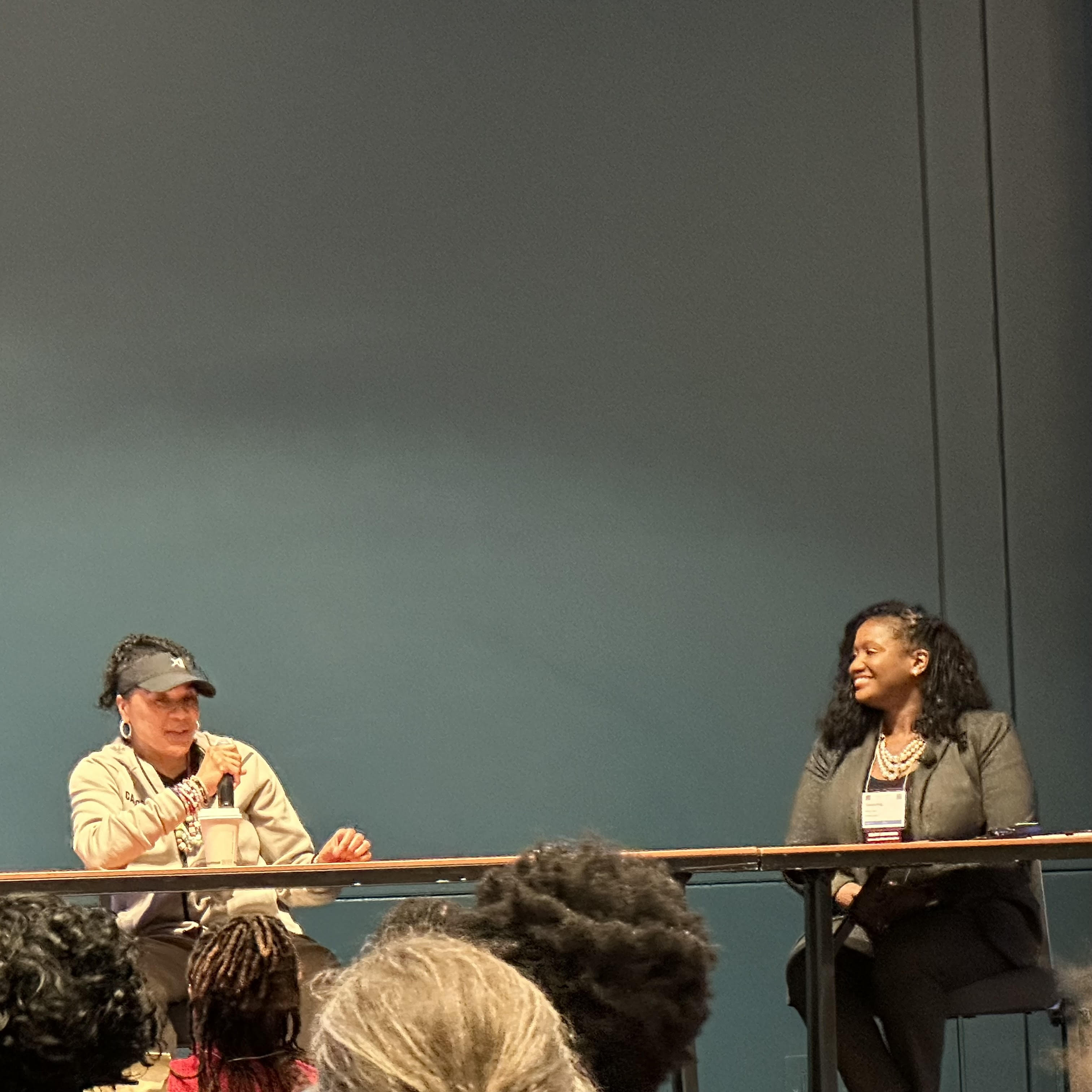 two women on a dias talking in microphone