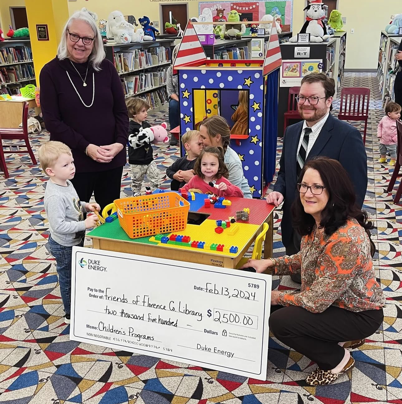 Paula with Alan, Duke Energy representative, children and a big check