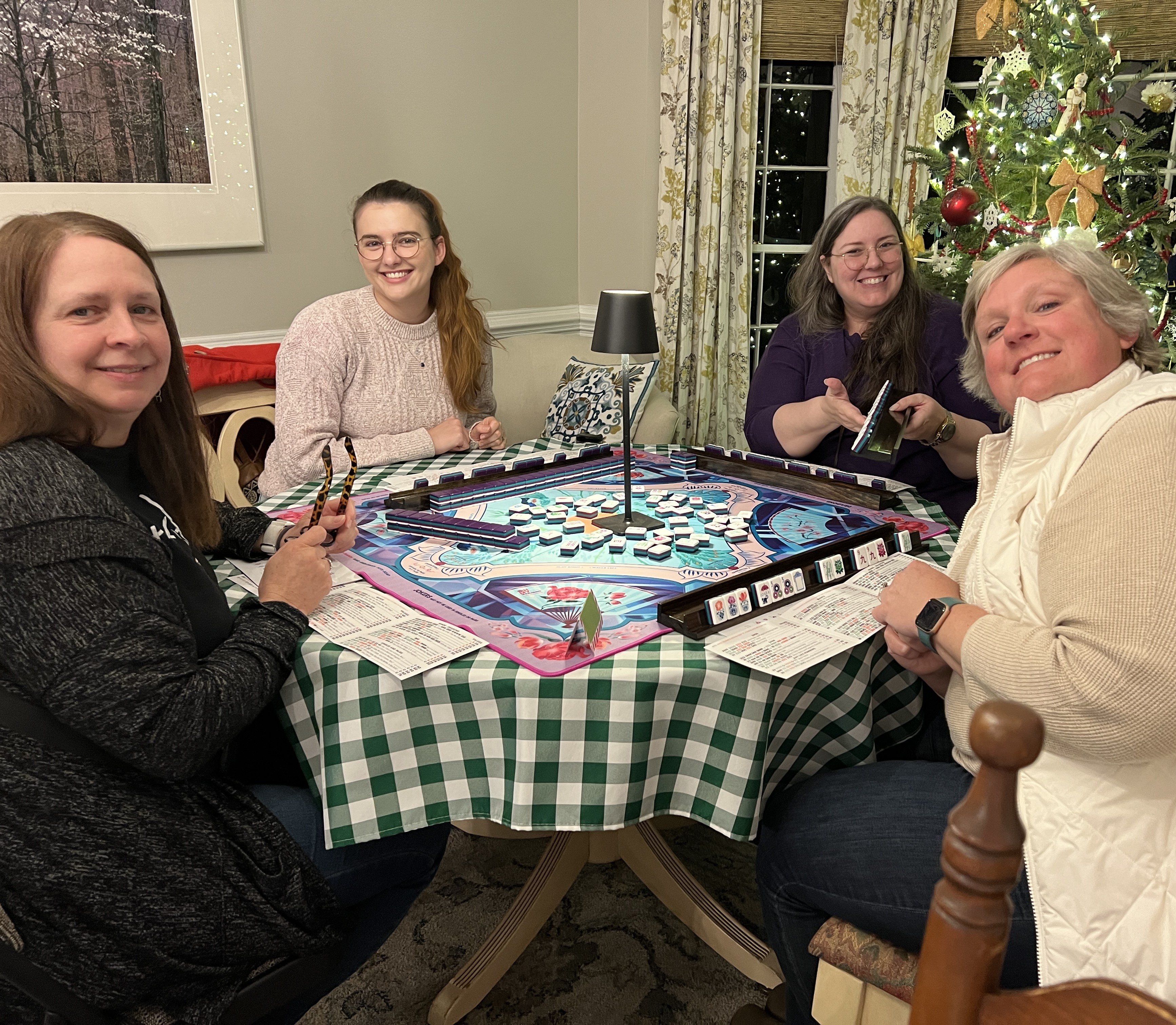 Mikaela and three other women sitting around a mahjong table