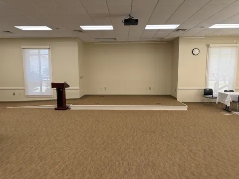 View of Lake City Community center, room with stage, podium, projector, and microphone.