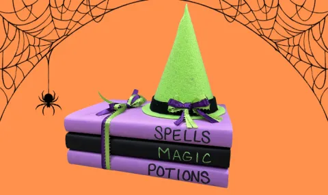 Stack of books with witch hat on top and spider web border