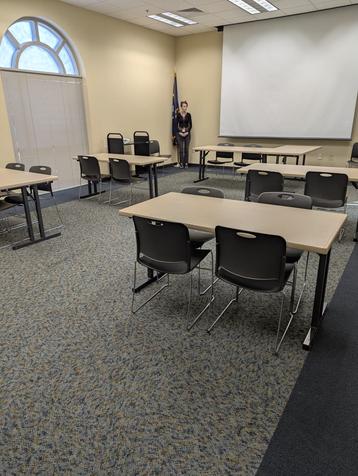 View of Olanta meeting room with tables, chairs, and screen.