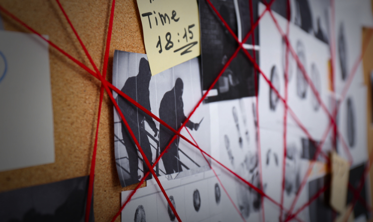 Bulletin board with red string on documents and crime notices