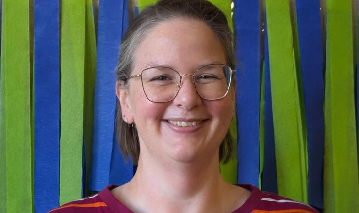 Headshot of Rachel, lady with light brown hair and glasses, smiling