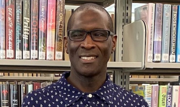Michael wearing glasses in front of book shelves