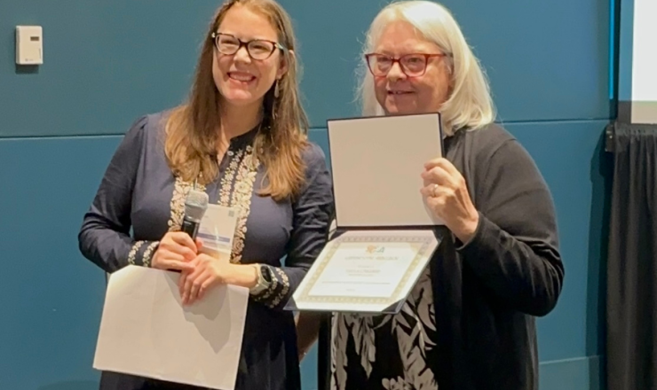 Two women holding a reward