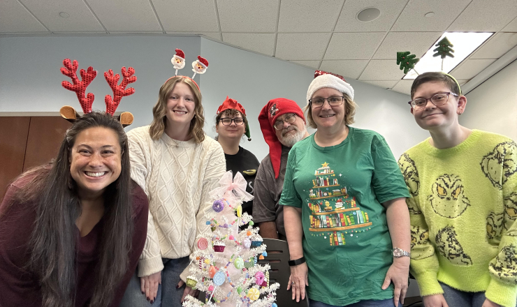 Group of writers standing around a Christmas tree