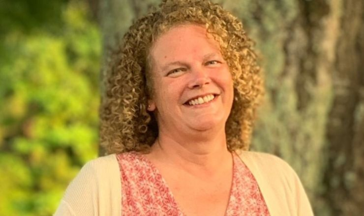 Headshot of Penny, smiling lady in front of tree